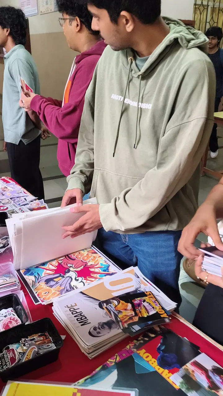 Browsing posters and sticker sheets at the pop-up