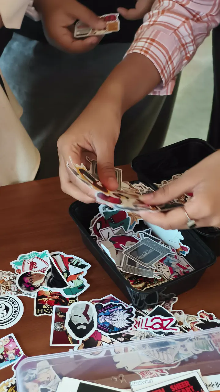 Hands sorting through a box of die-cut stickers